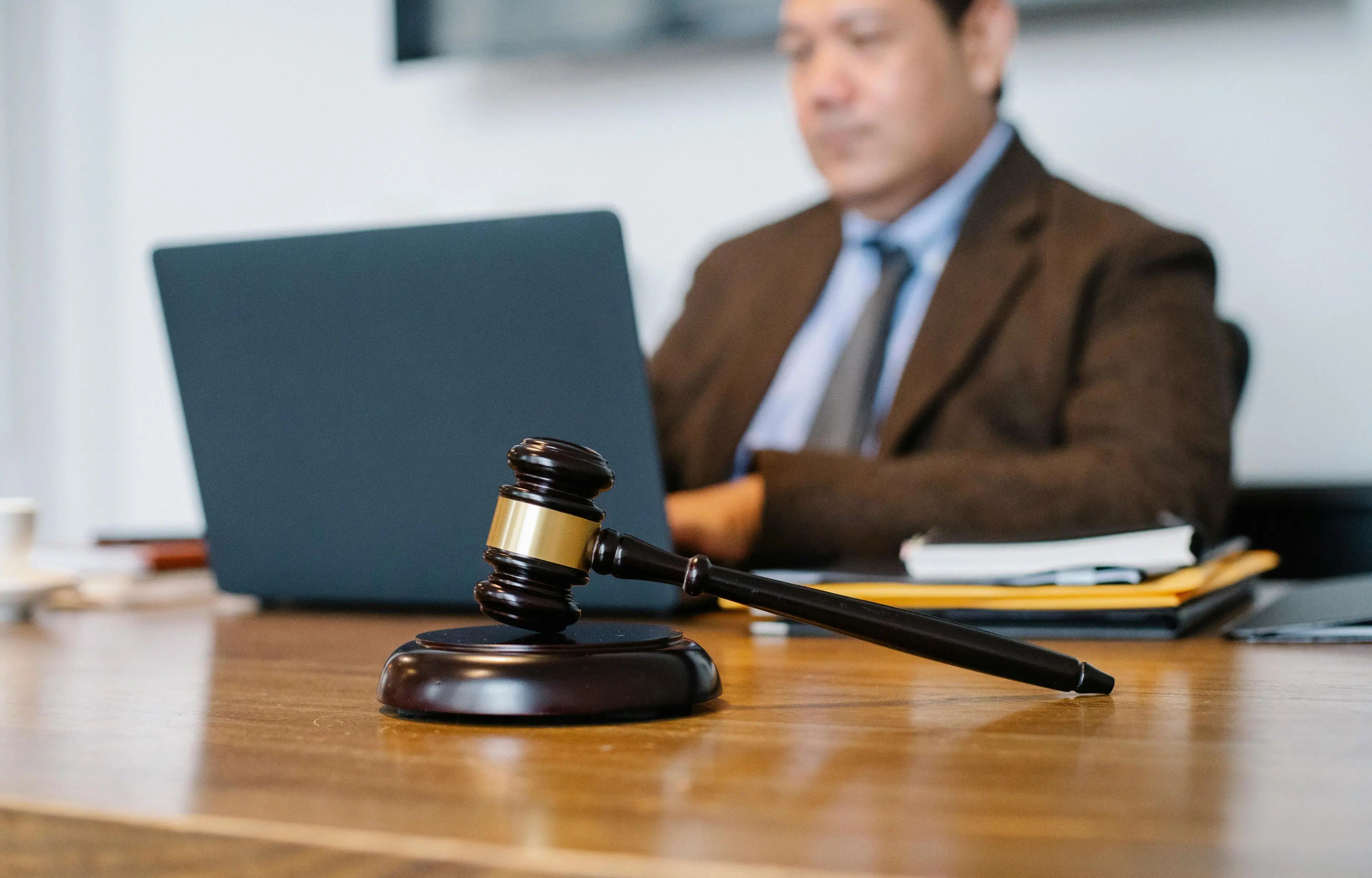 A lawyer and an applicant sit across a desk during a USCIS citizenship interview, with an American flag and USCIS documents visible. The text overlay reads “Benefits of Having a Lawyer at Your Citizenship Interview.”